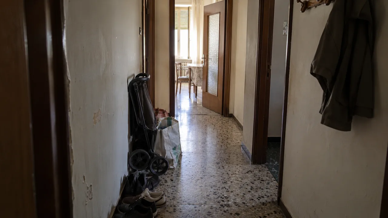 Corridoio stretto in una casa da ristrutturare con borse e scarpe accumulate